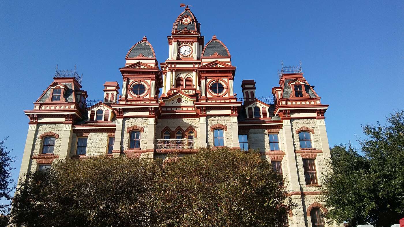 The Caldwell County Courthouse clock tower rising over trees in Lockhart